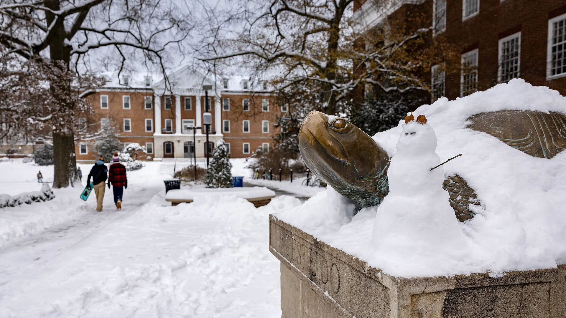 Testudo statue covered in snow, with tiny snowman