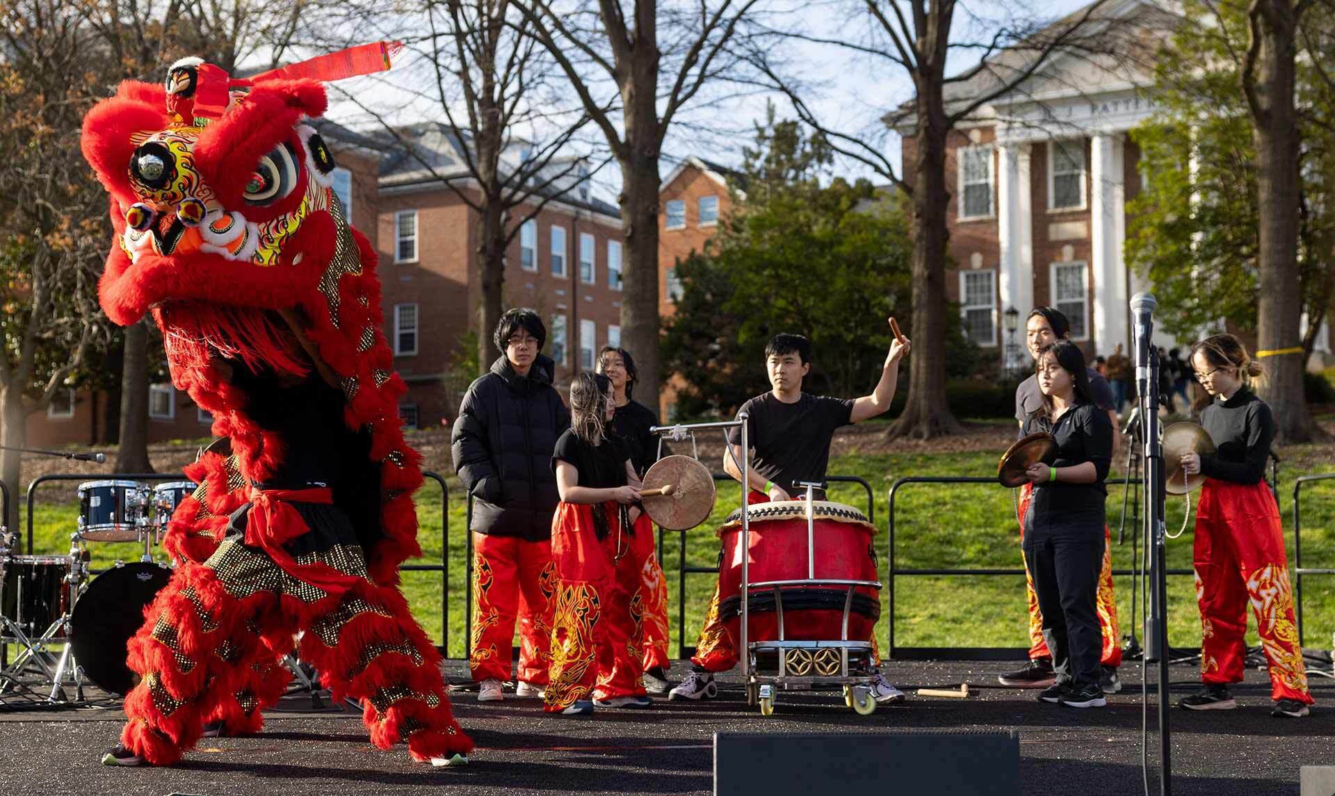 student dance group dances and plays drums