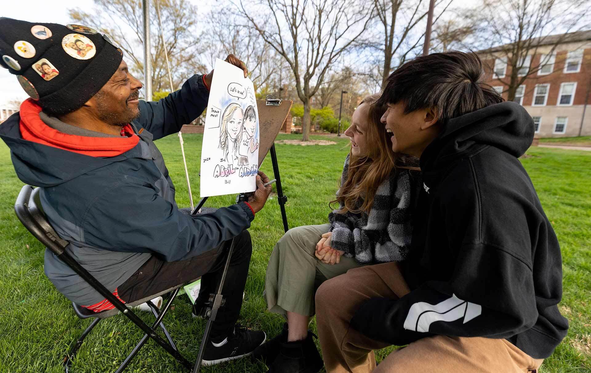 an artist shows a caricature to a subject