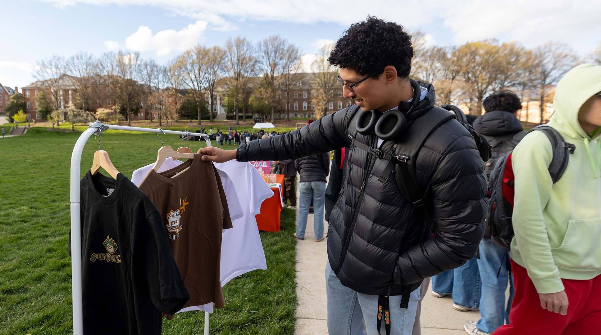 person looks at clothes on rack
