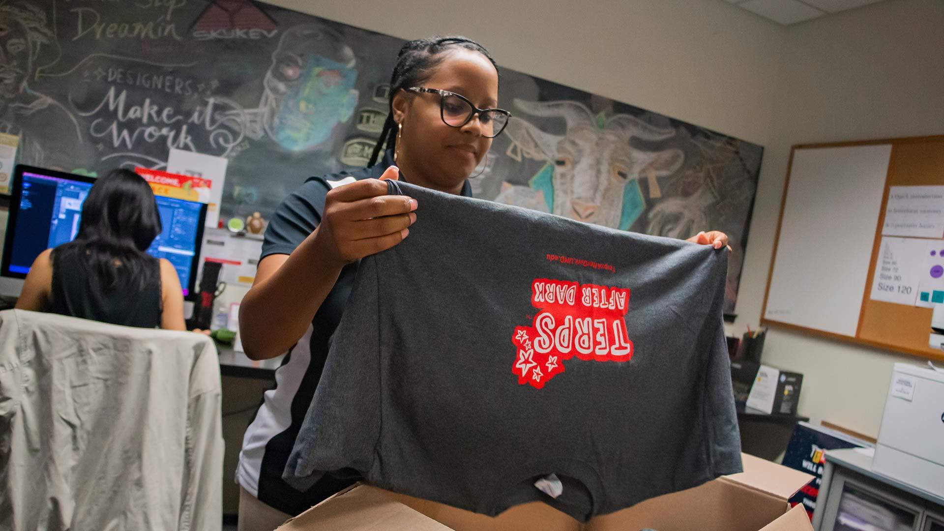 Staff member folds T-shirt
