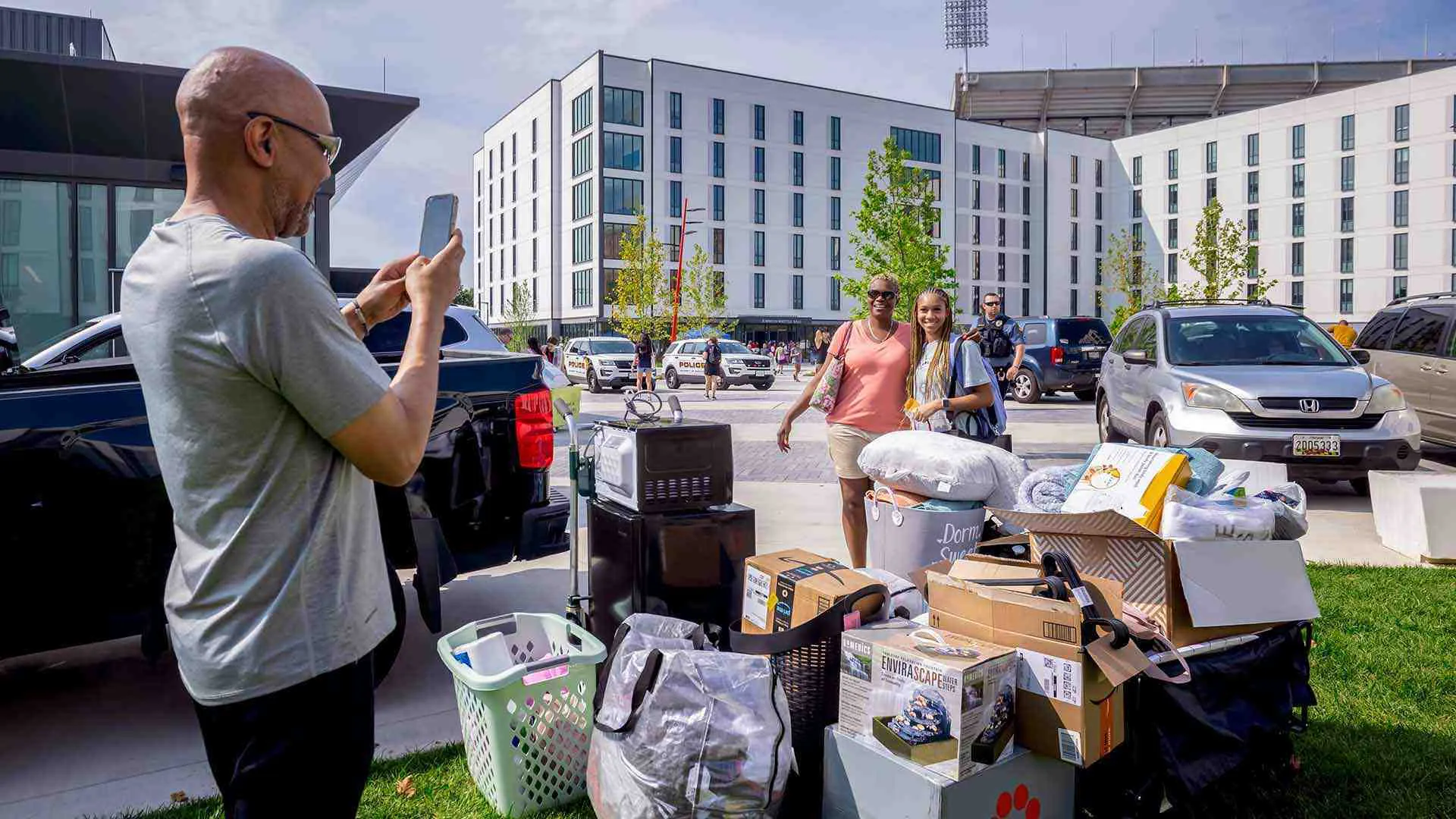 man takes photo of wife and daughter during move-in