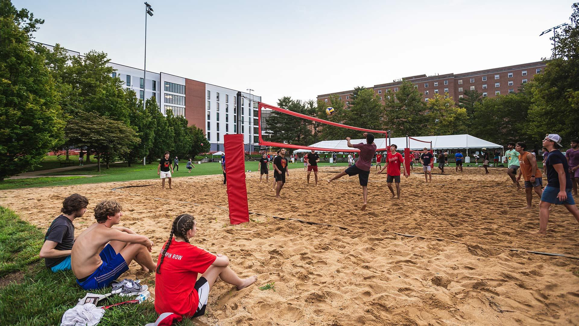 students play beach volleyball