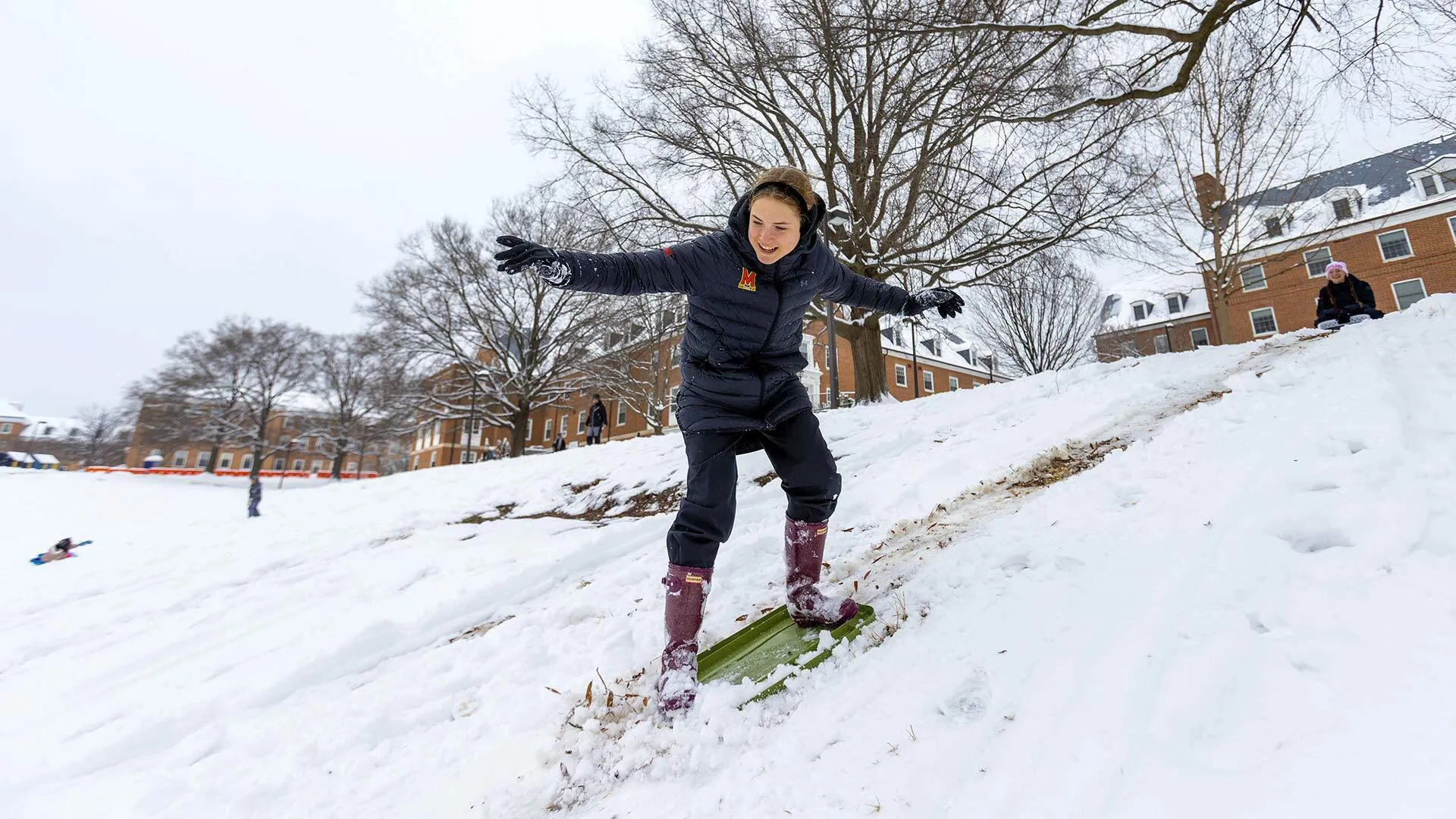 student snowboards down a McKeldin Mall hill