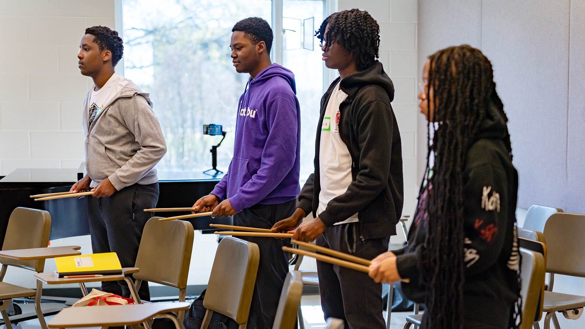 People drum on chairs backs