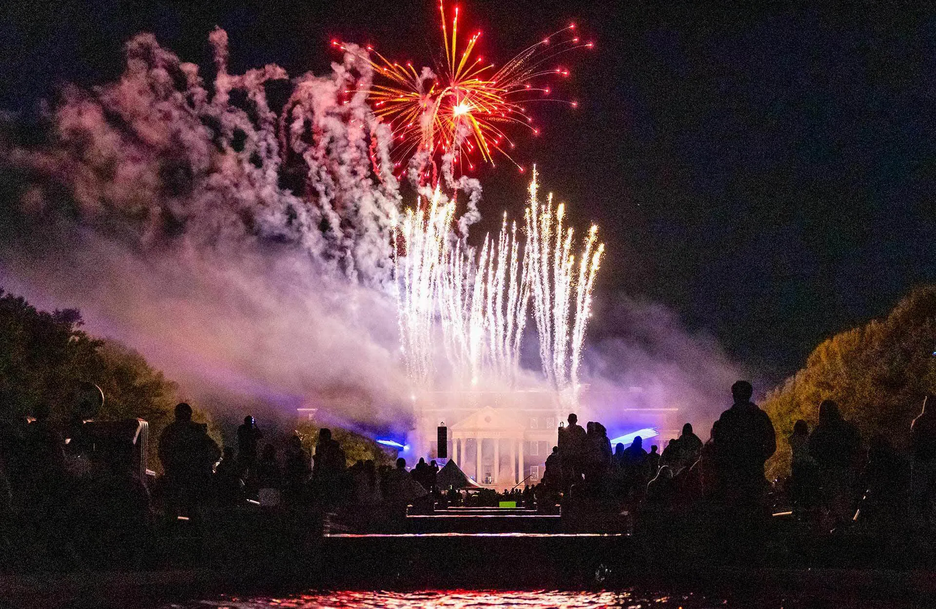 Crowds watch while fireworks explode over UMD's central mall, and smoke hovers in the air