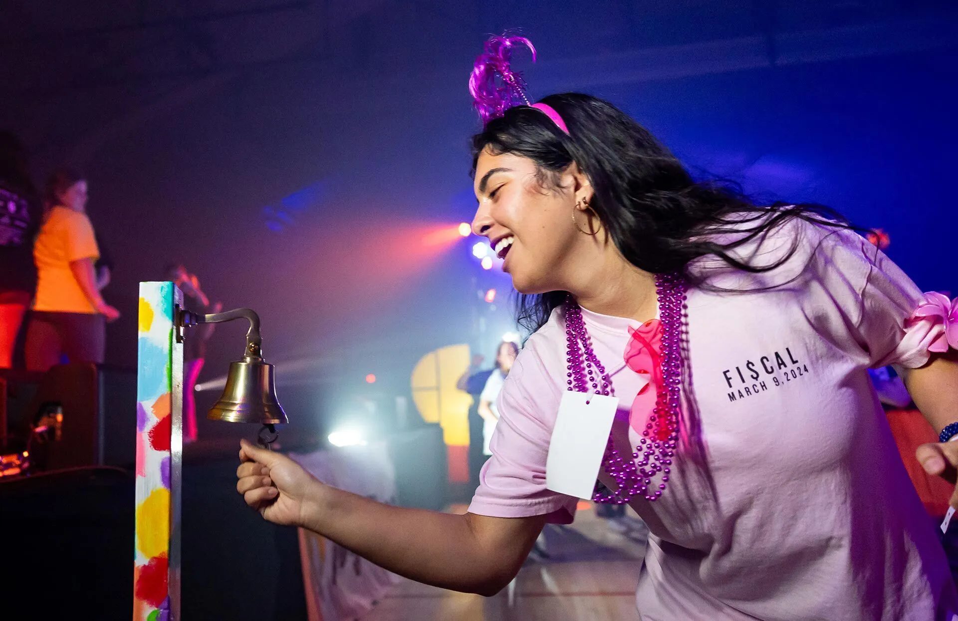 woman in a pink shirt rings a bell