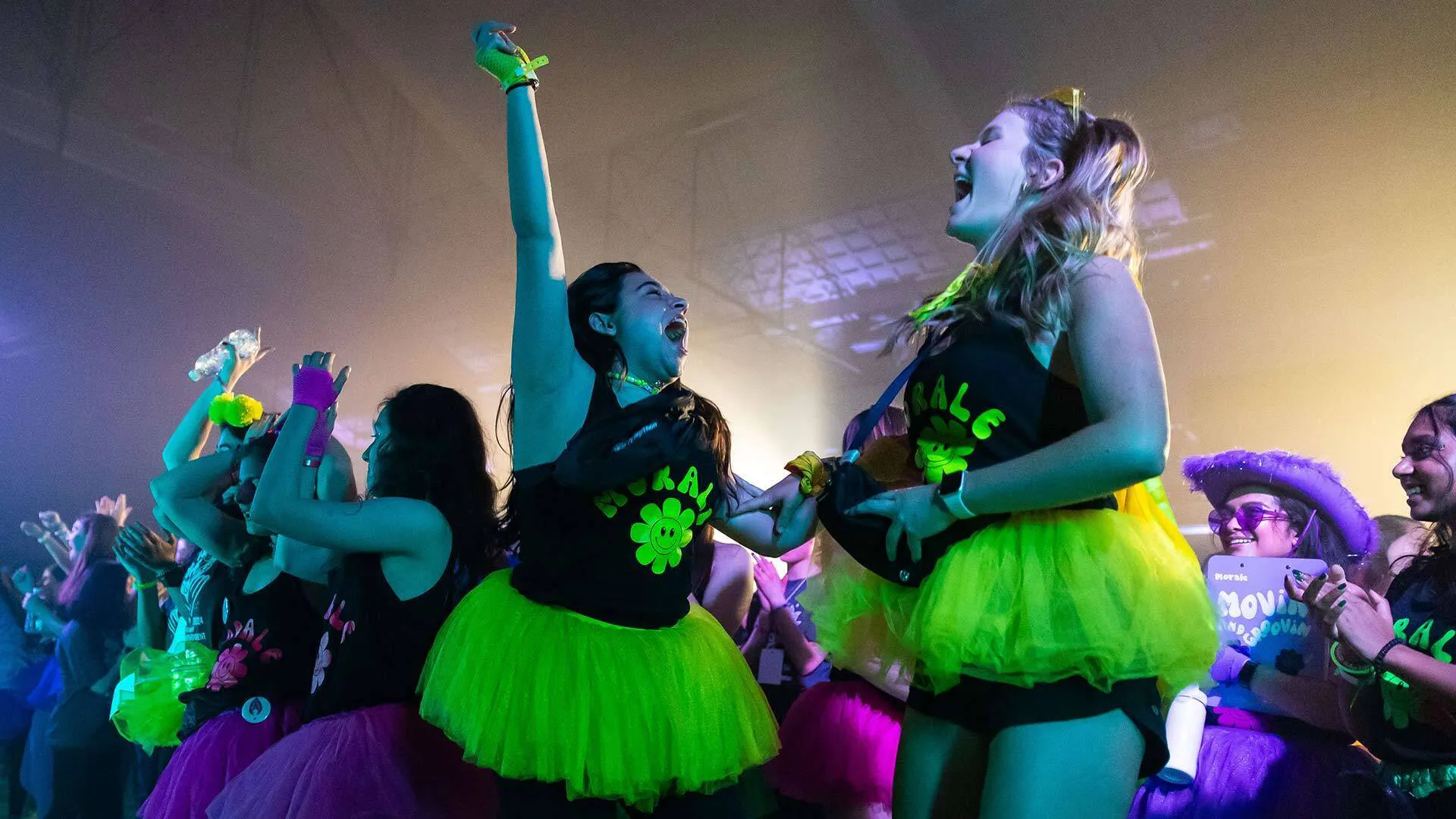 WOmen in green tutus celebrate at a dancse