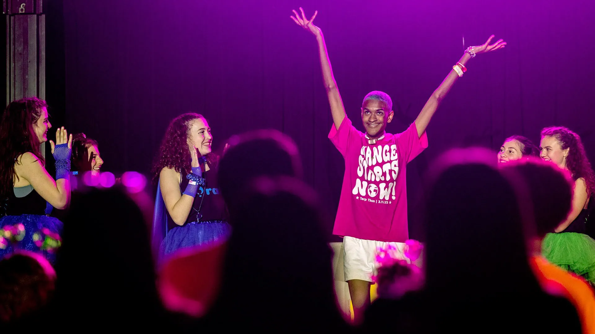 Dancers on stage with one raising his hands