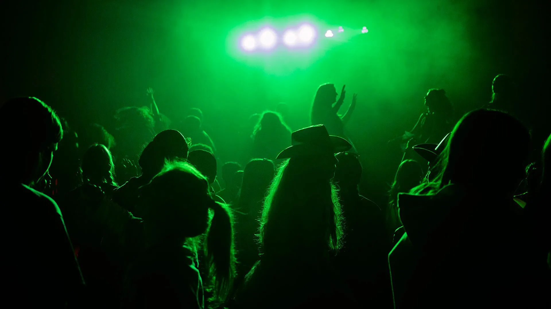students dance in green light