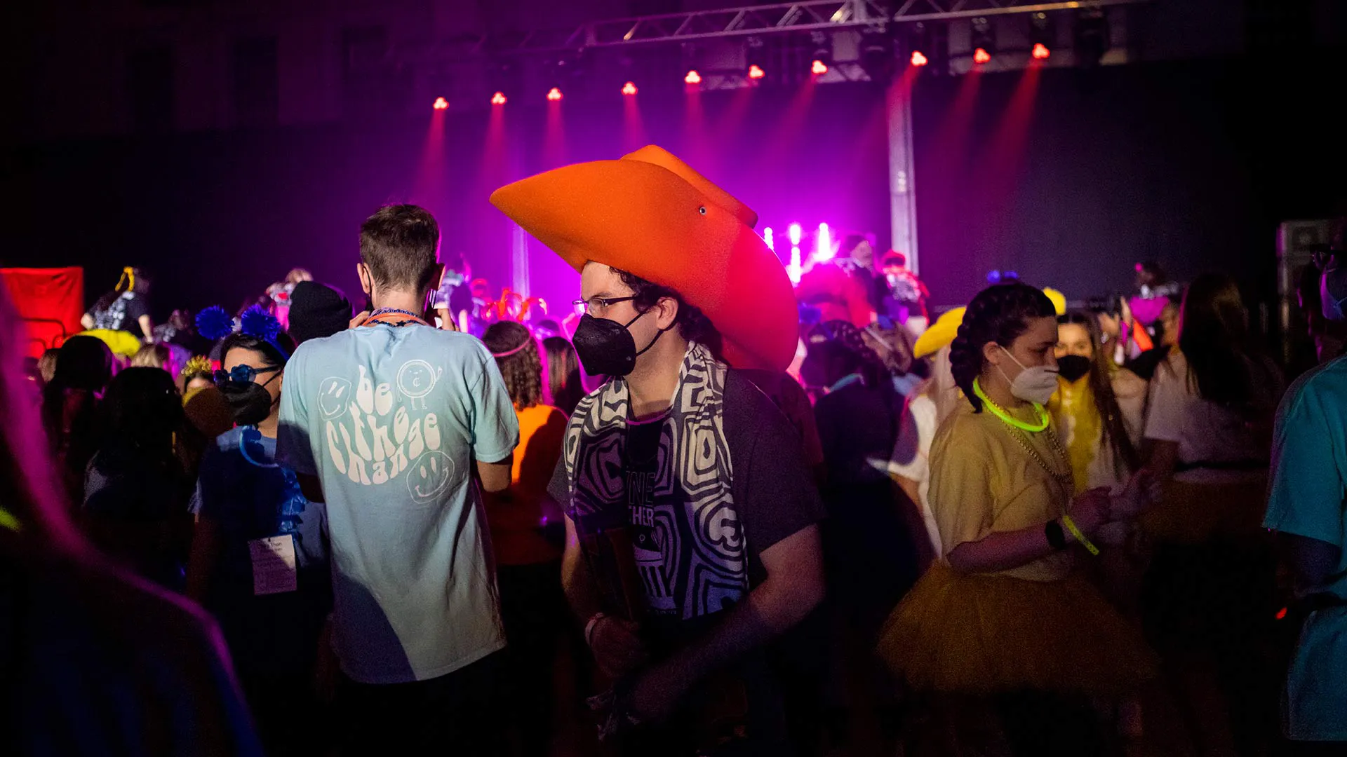 Dancer walks about ina big orange foam cowboy hat
