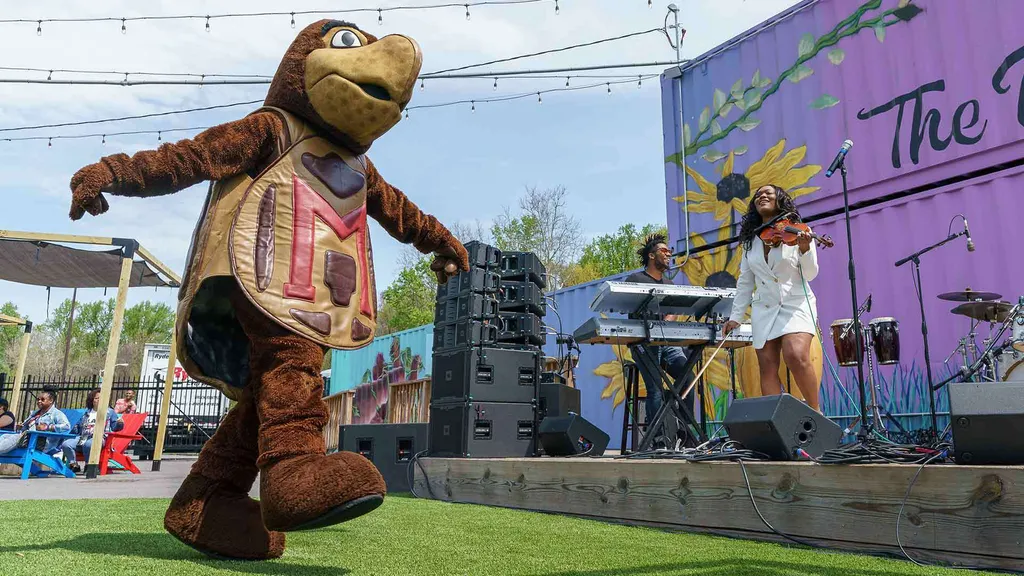 Testudo dances as Chelsey Green plays