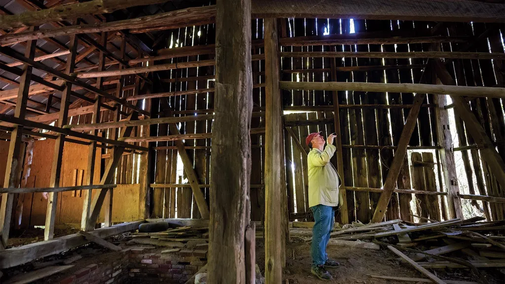Dennis Pogue examines a tobacco barn