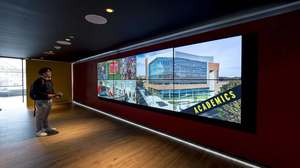 Student Jeffrey Flores looks at video board in Visitor Center