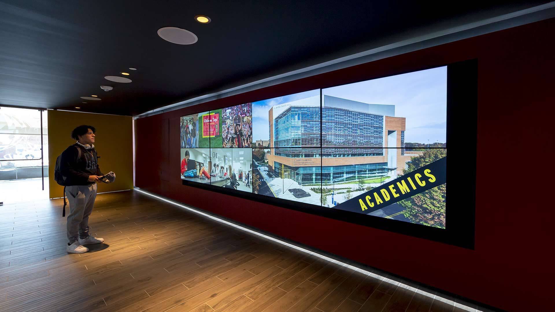 Student Jeffrey Flores looks at video board in Visitor Center