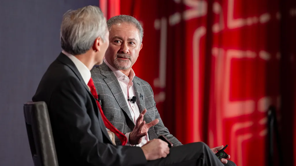 Two guys talk on a stage