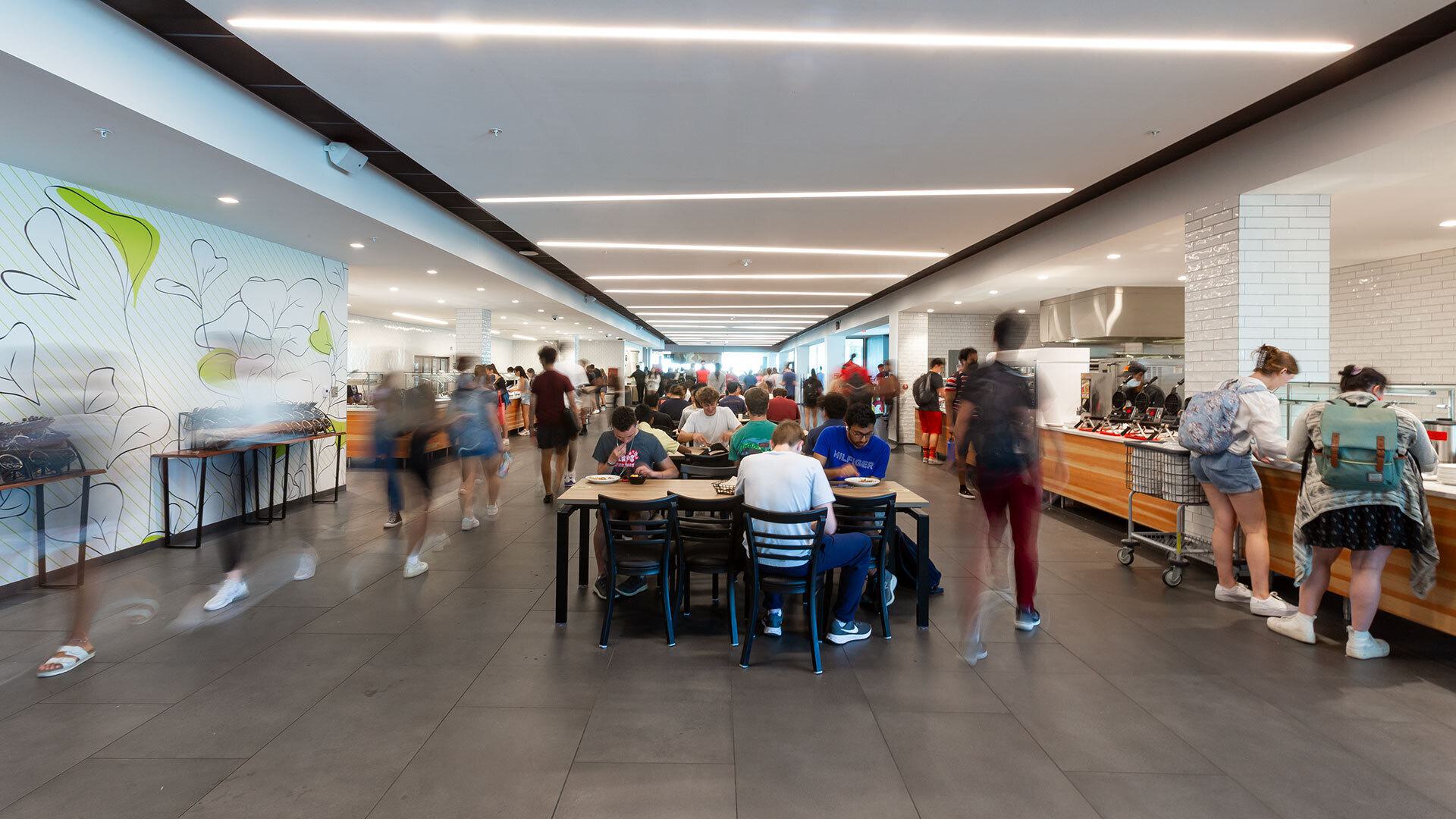 Students walking around and sitting at tables at Yahentamitsi dining hall