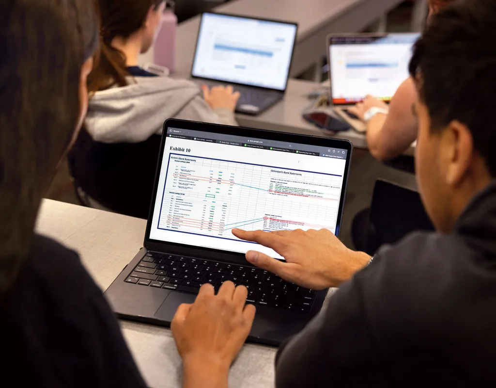 students analyze spreadsheet on laptop