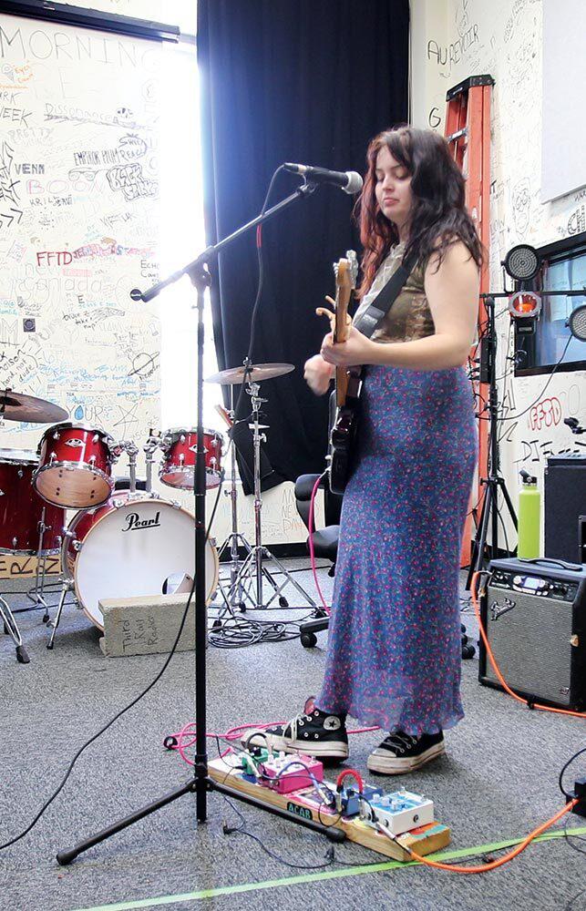 student plays guitar in live room
