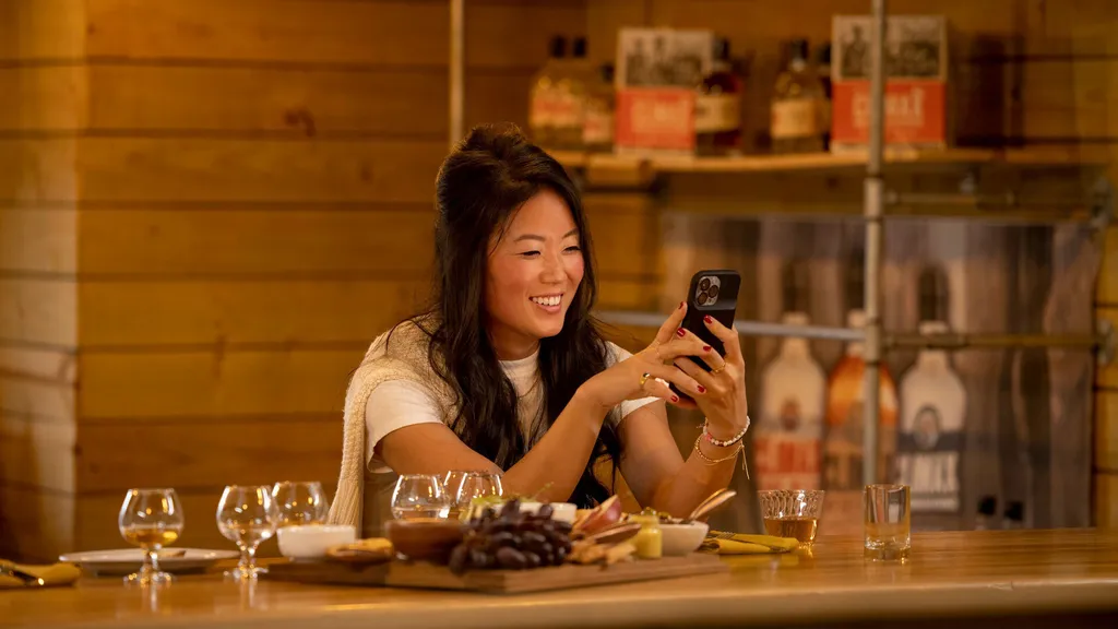 Kesun Lee smiles while looking at her phone