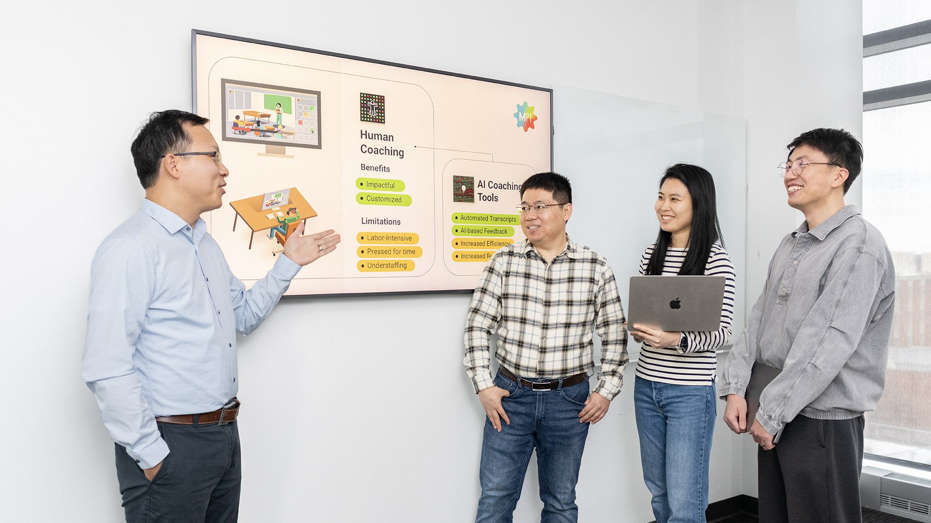 Researchers standing by a screen with information about human coaching