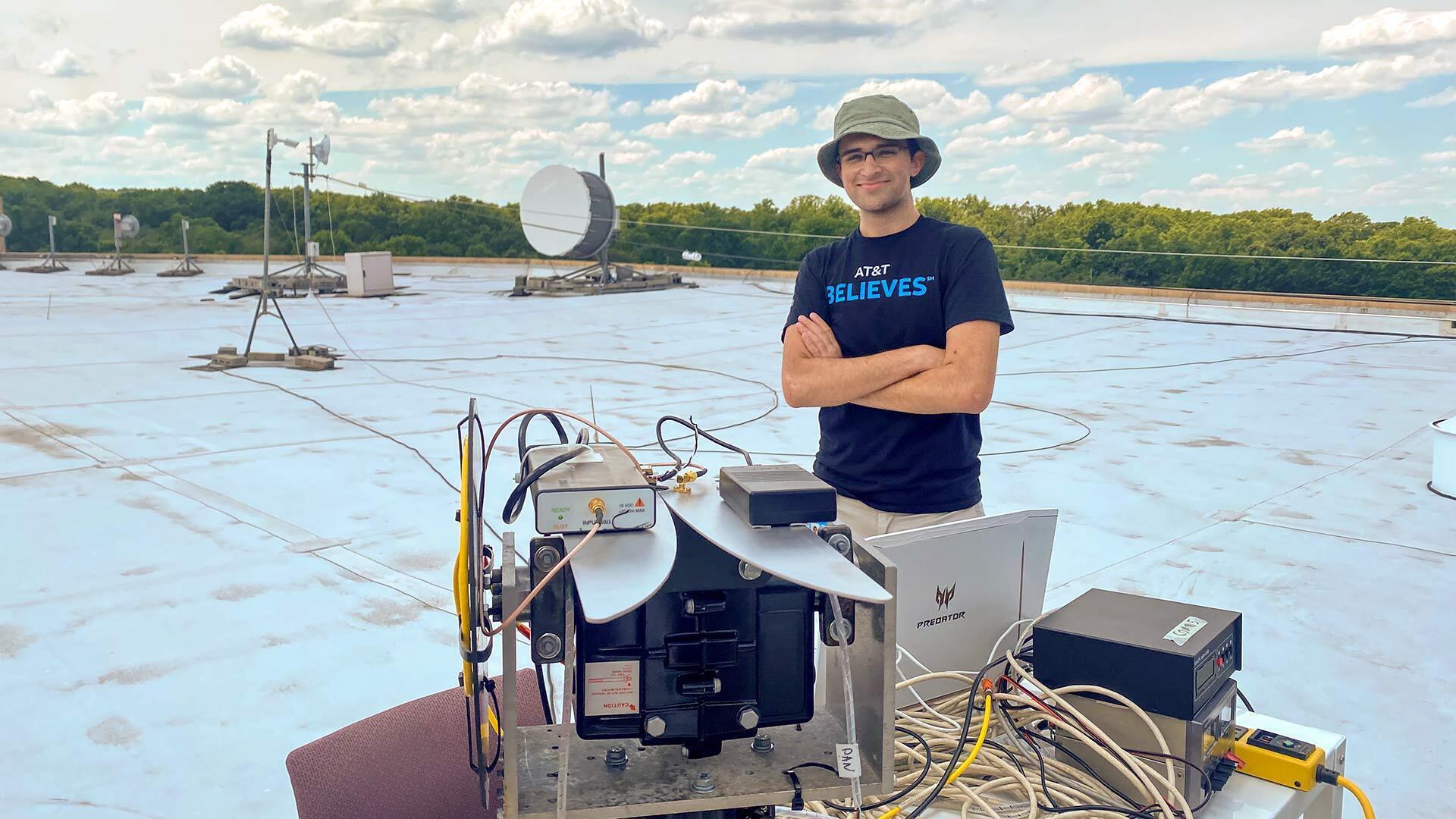 A student on a rooftop with devices