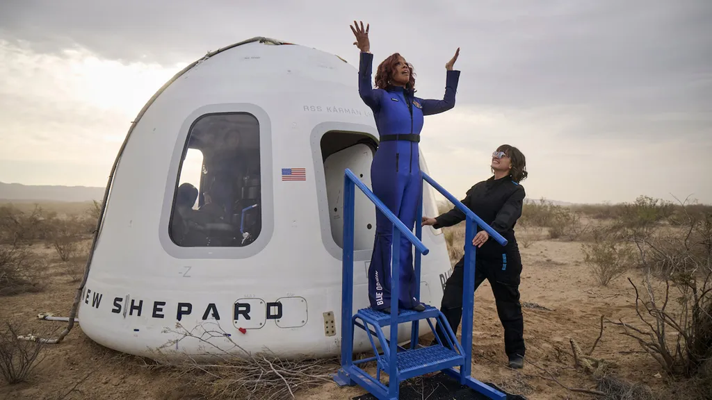 Gayle King raises arms after exiting capsule back on Earth