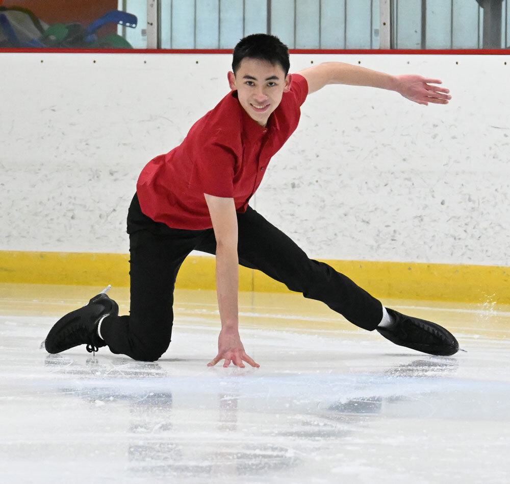 Allen Yuan kneeling with one arm down on the ice