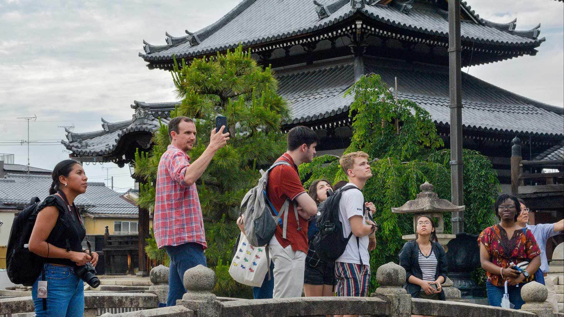 students take pictures at temple in Japan