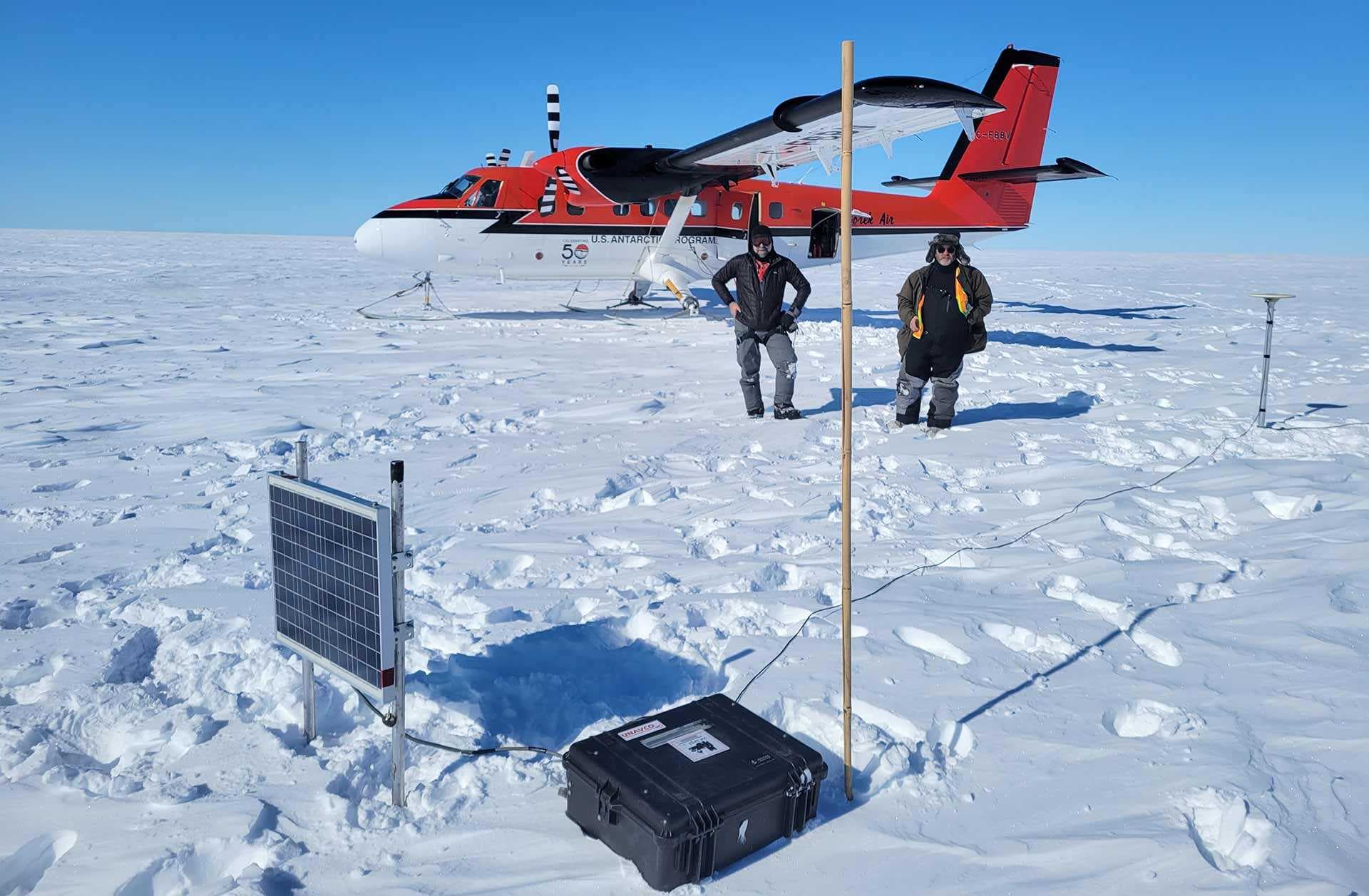 researchers with equipment and plane in Antarctica