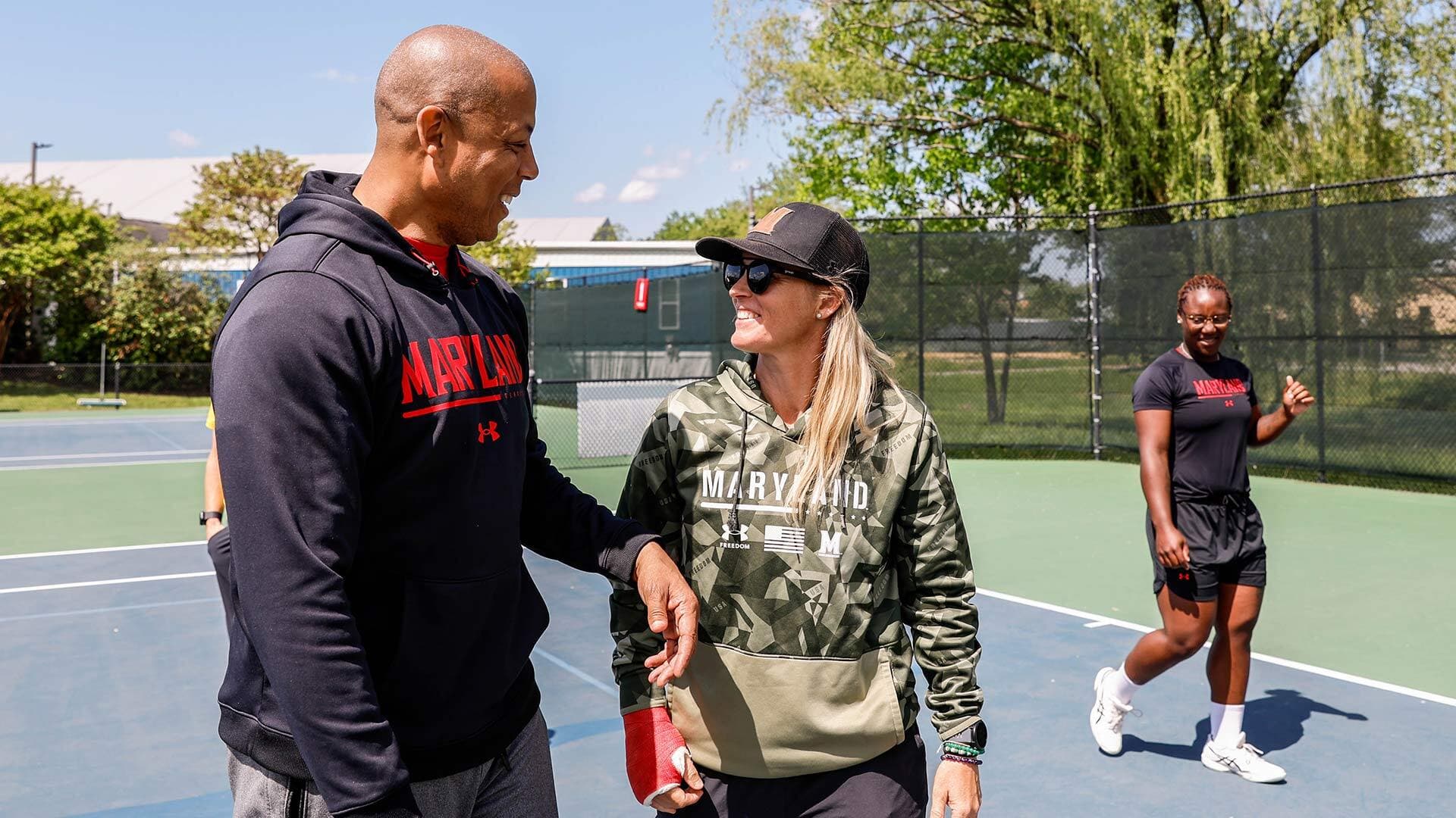Evans talks to a woman on a tennis court