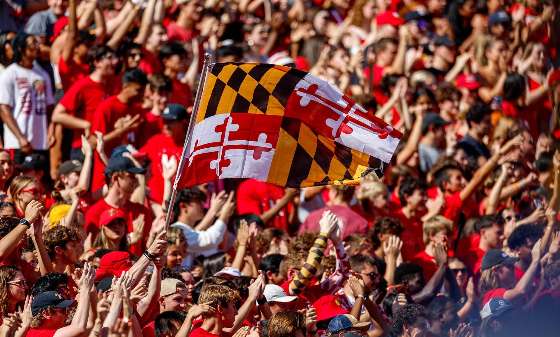 A Maryland flag waves above a crowd