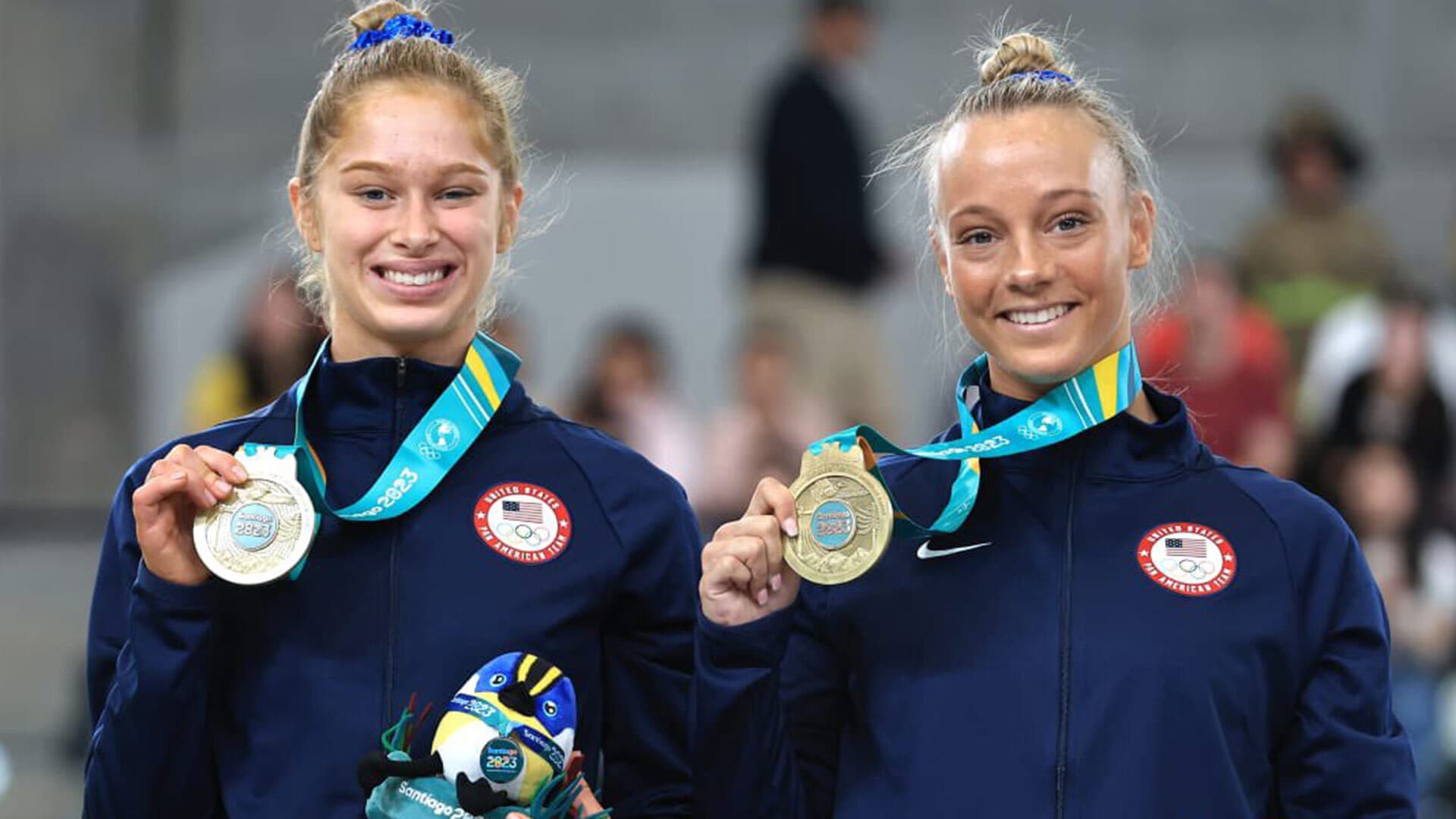 two female athletes show off gold medals