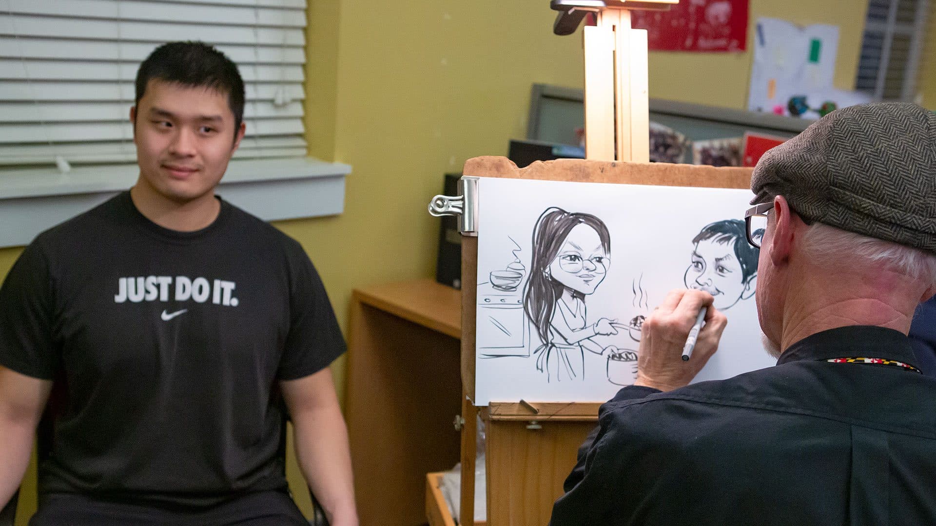 student poses for caricature artist