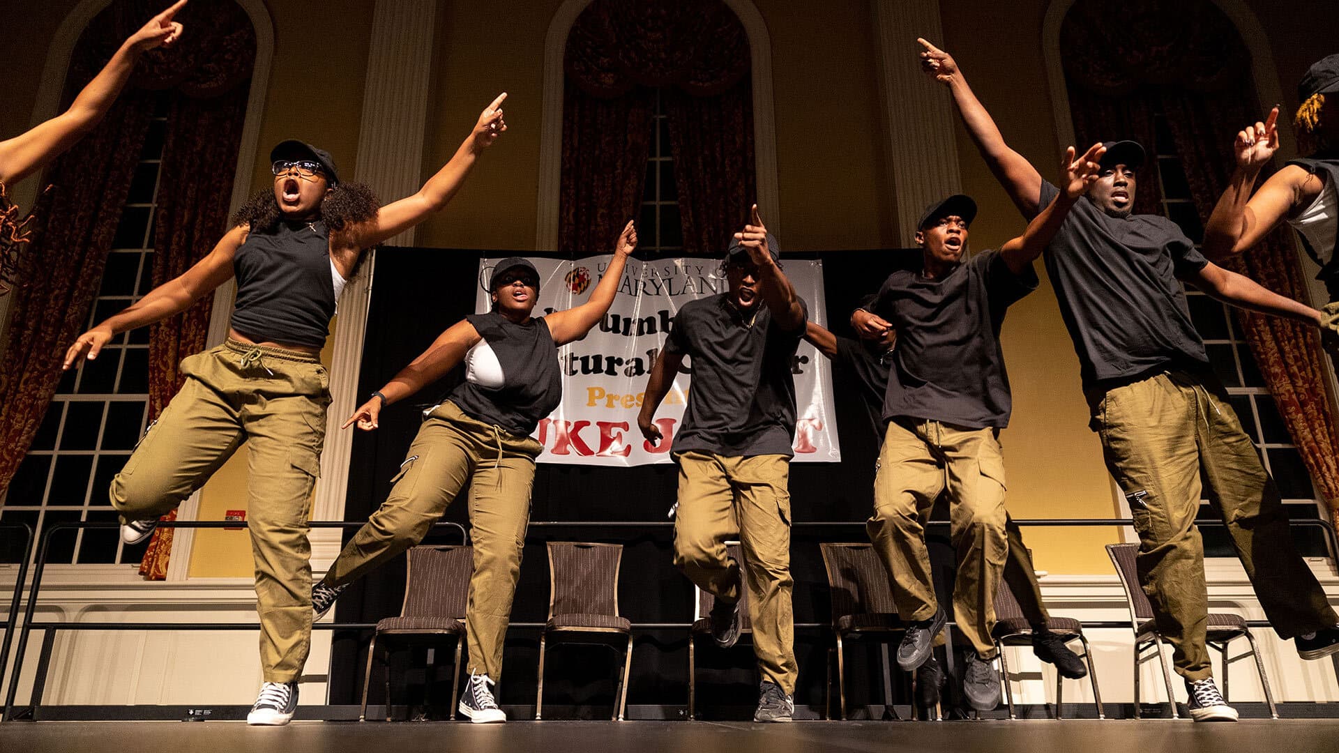several members of a dance team dance on a stage