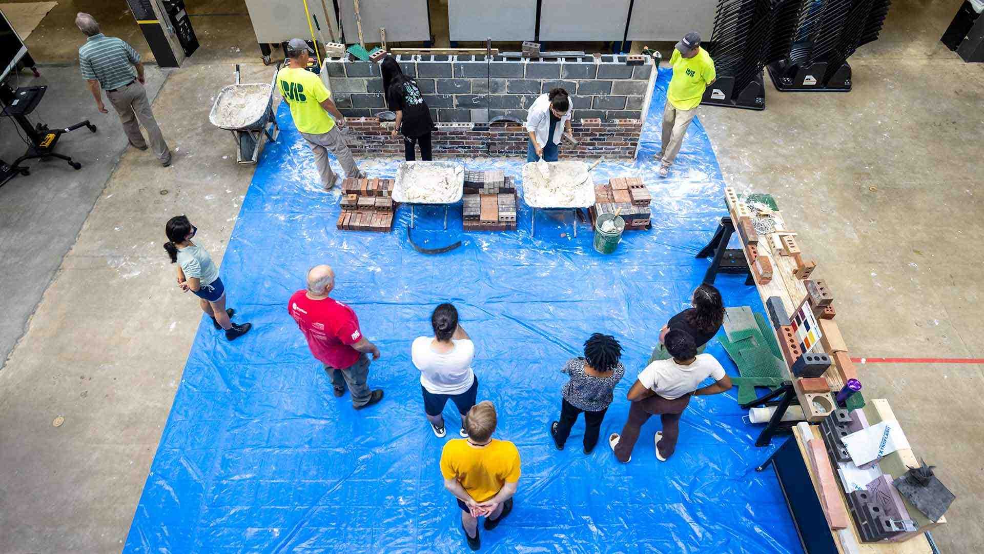 overhead view of students building brick wall