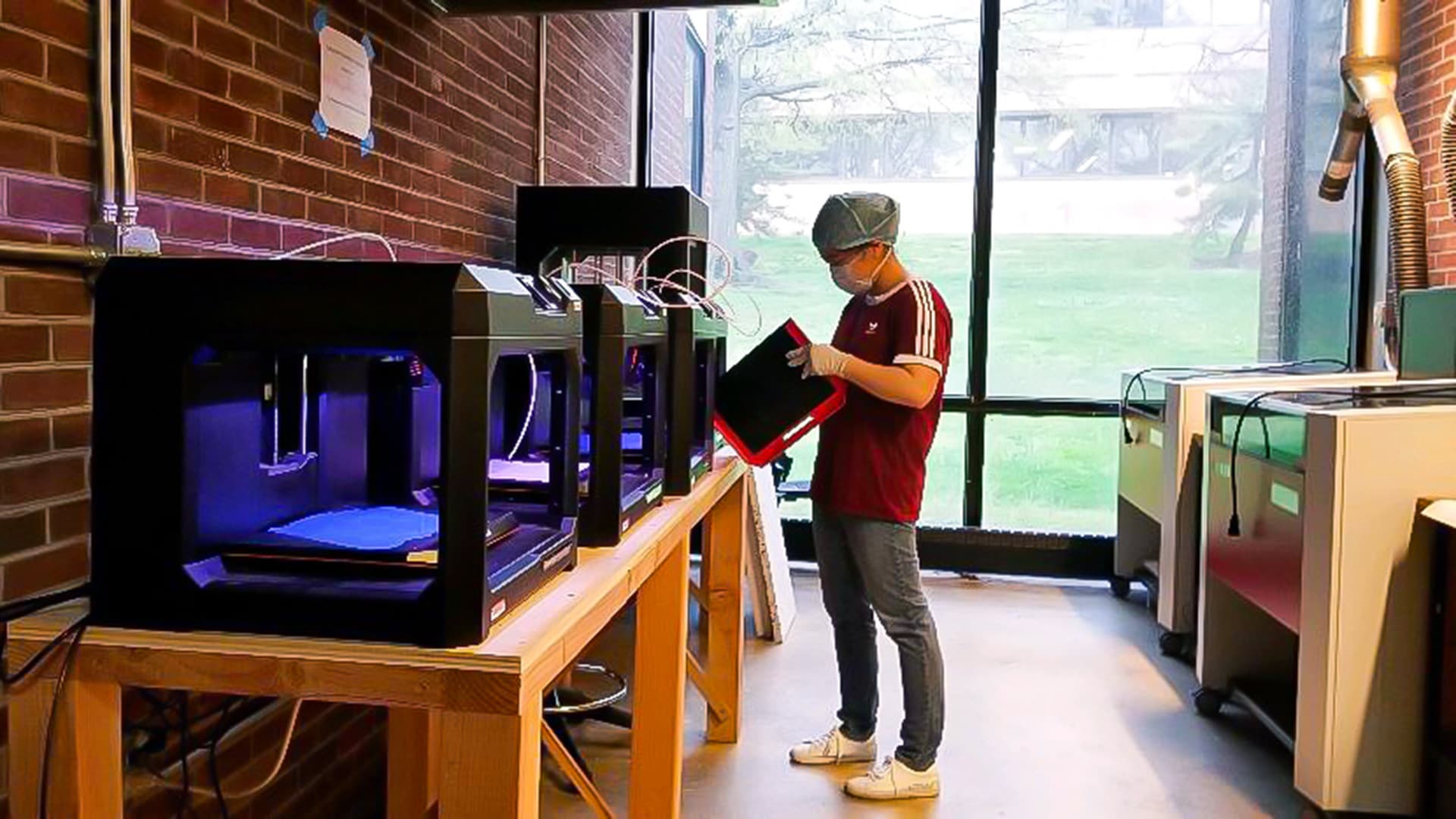 Student works with 3D printer in architecture FabLab