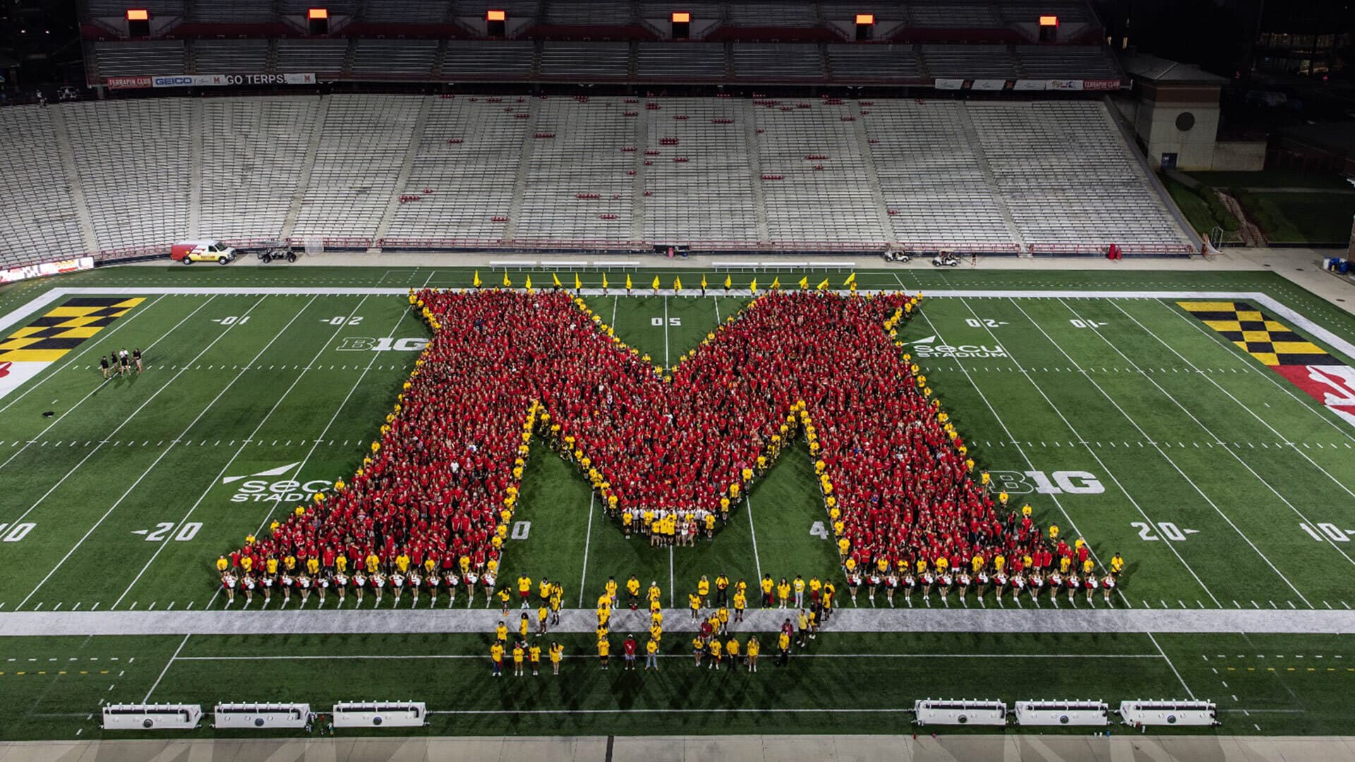 students form giant M on football field