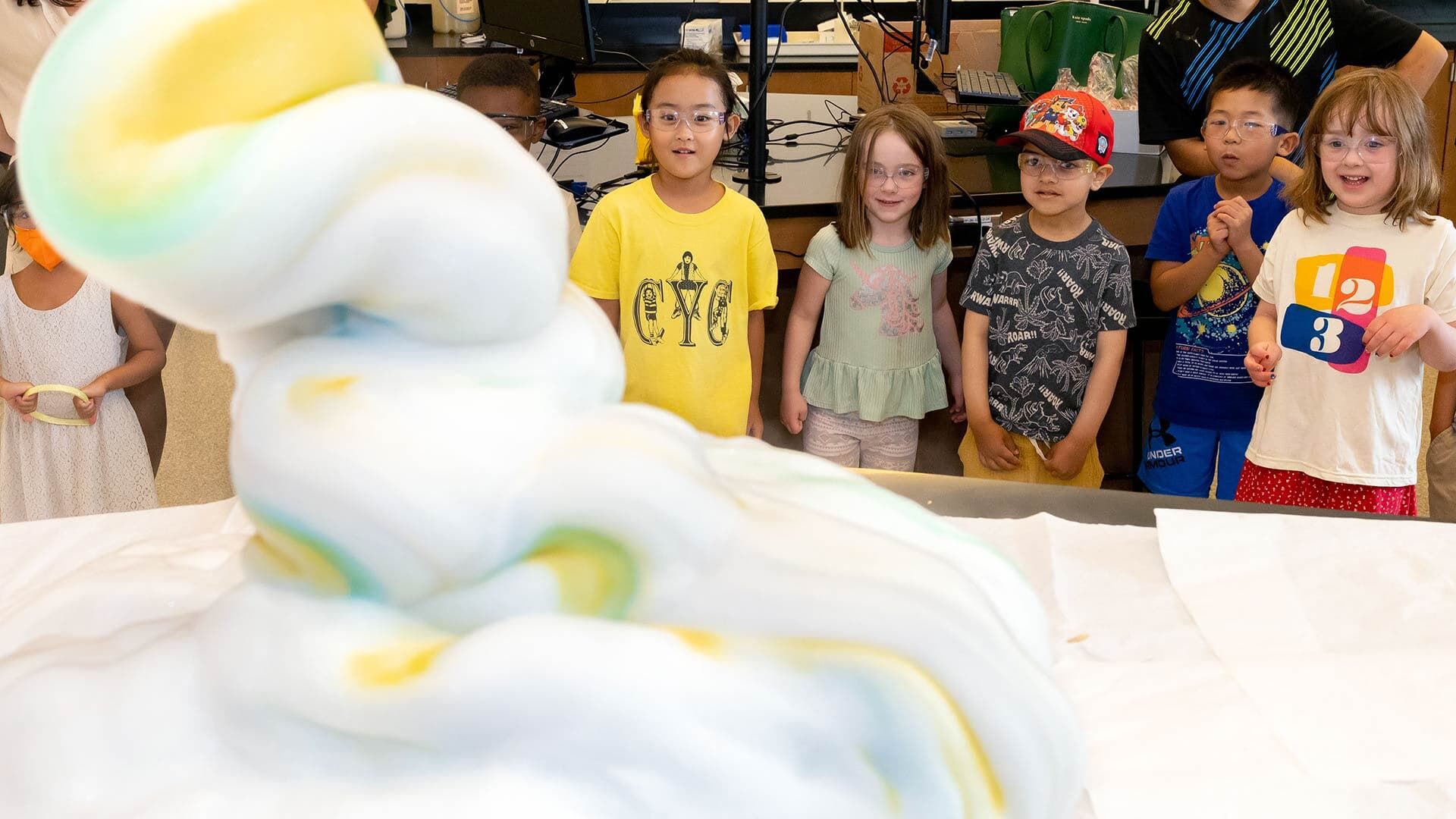 young students wearing protective goggles watch "elephant toothpaste"