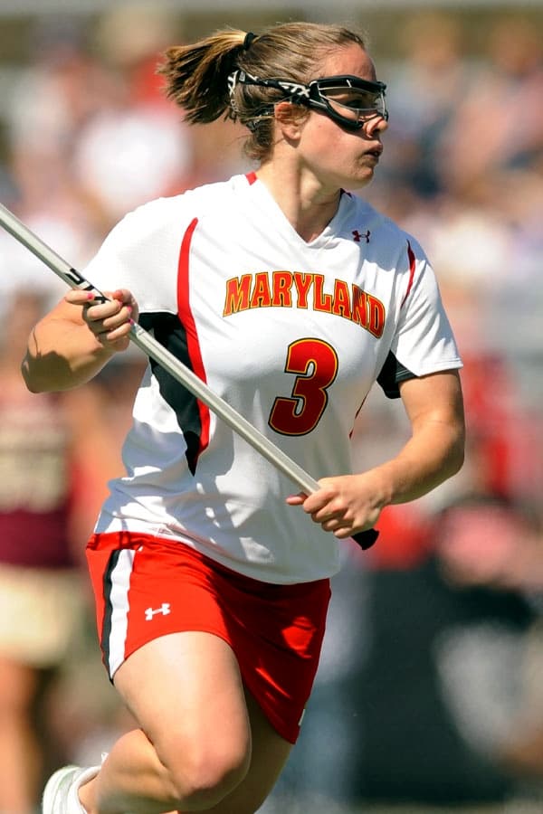 Female lacrosse player wearing goggles and holding a stick