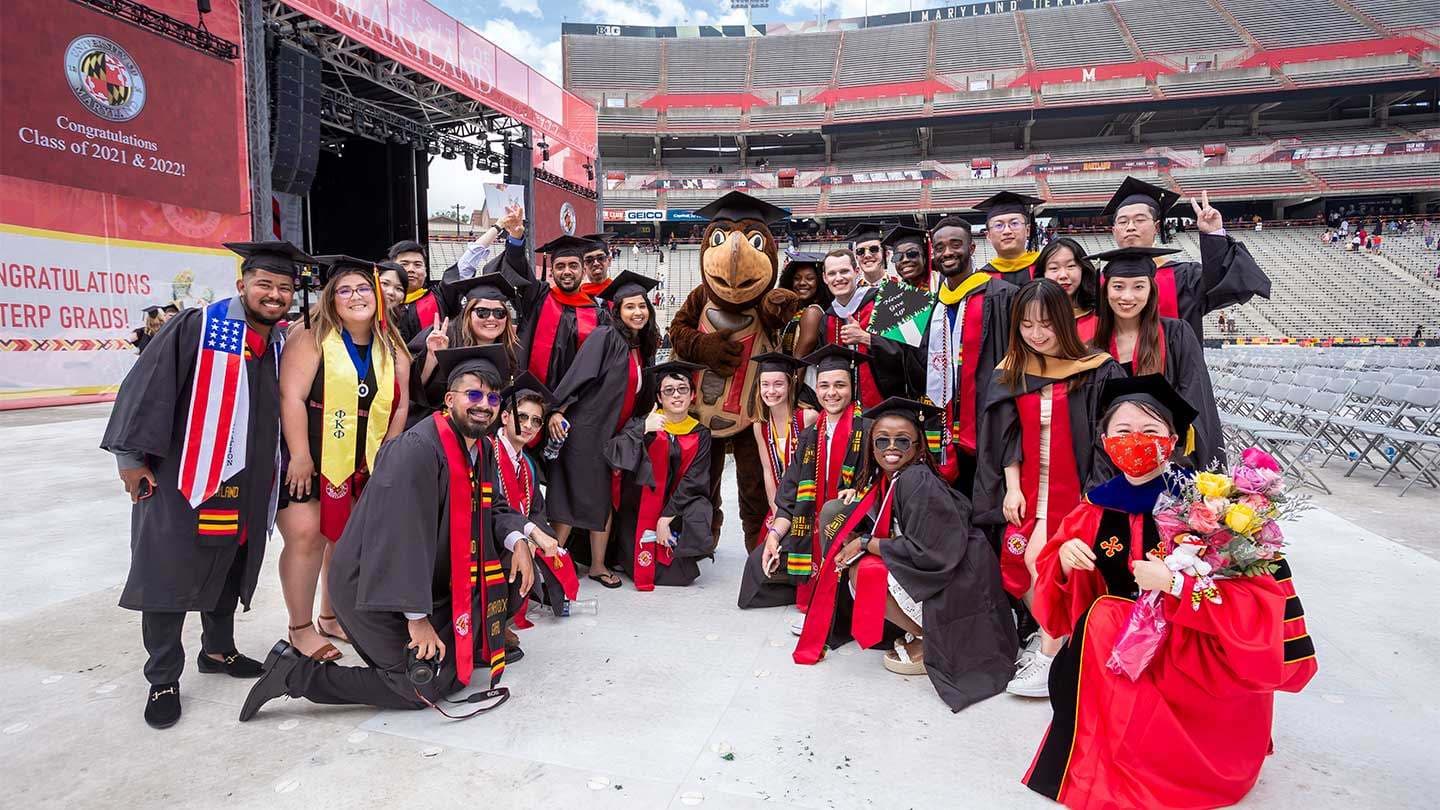 Students pose with Testudo at commencement