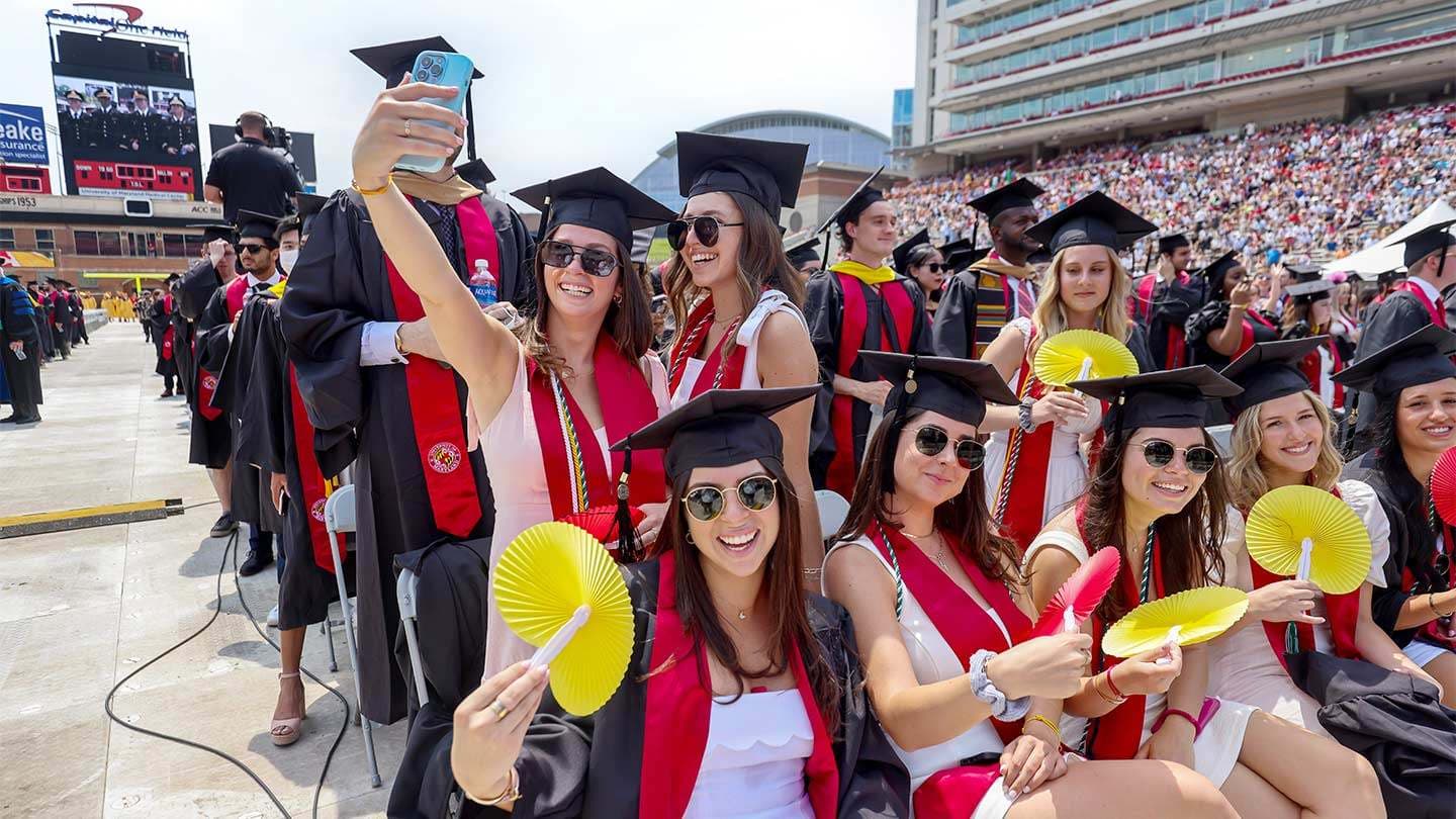 Students with fans at commencement
