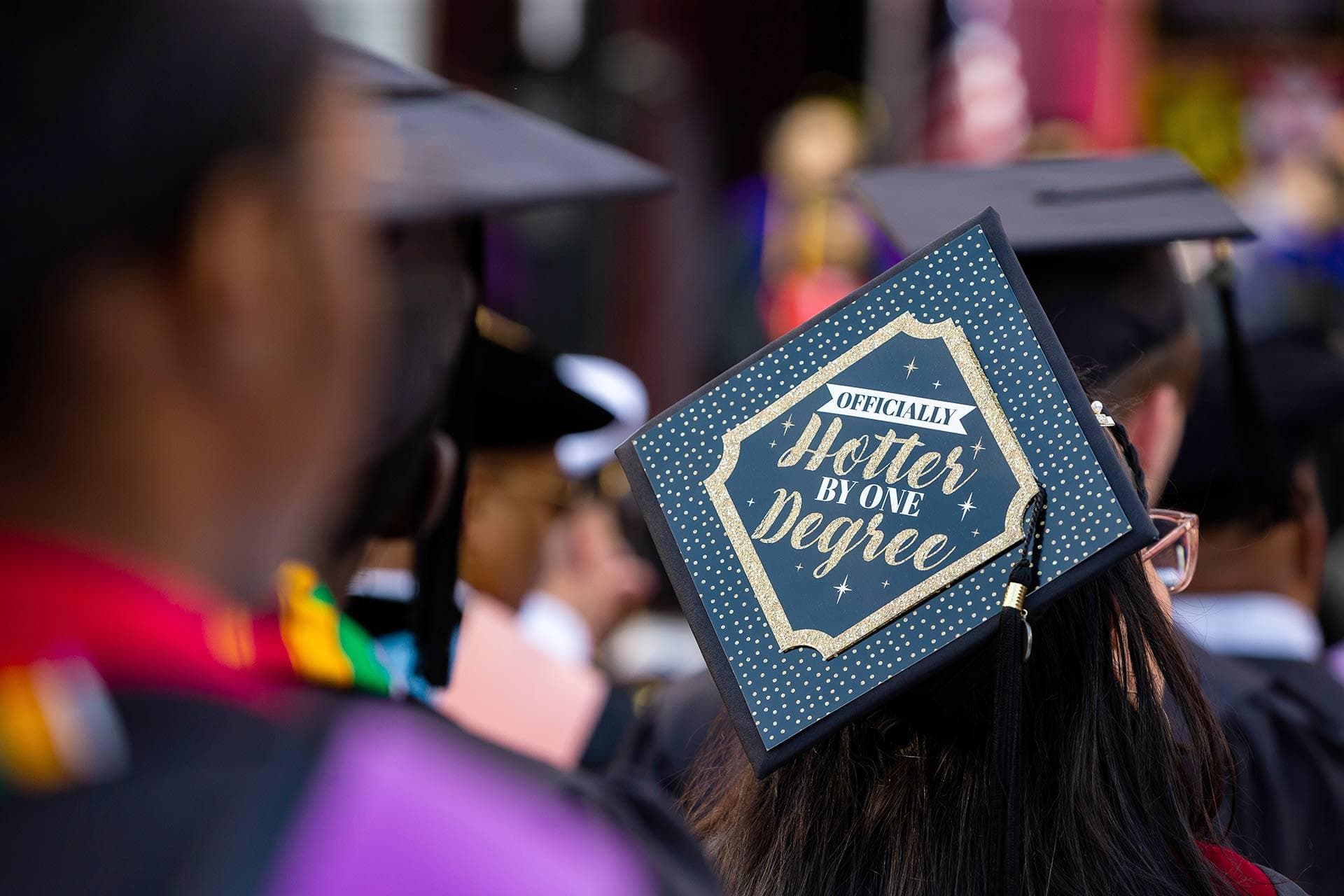 mortar board that reads, "Officially hotter by one degree"