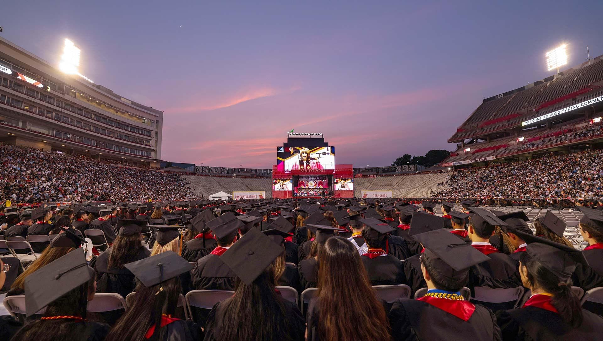 wide shot of Gayle King speaking at Commencement as sun sets