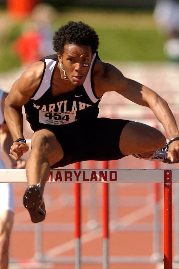 Man jumping over a hurdle on a track