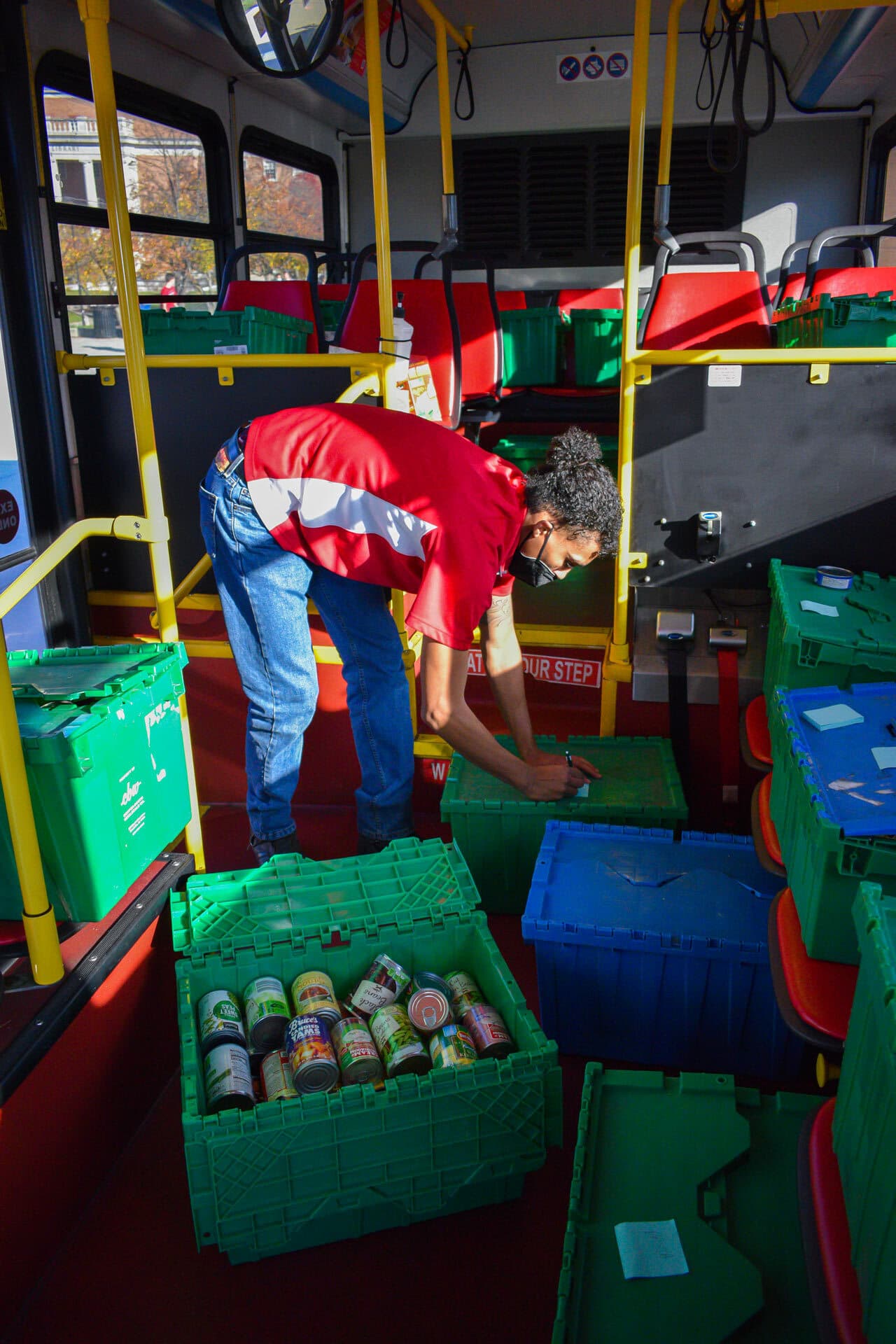 Students sort donations on bus during food drive
