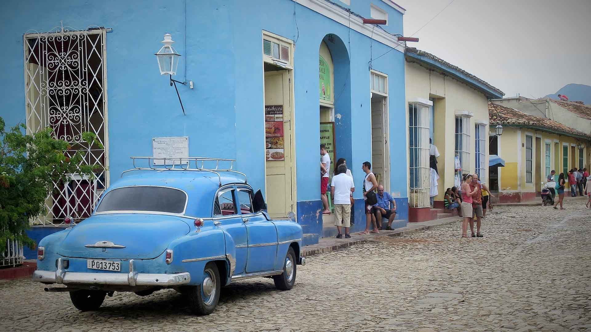 Blue car next to blue building in Havana