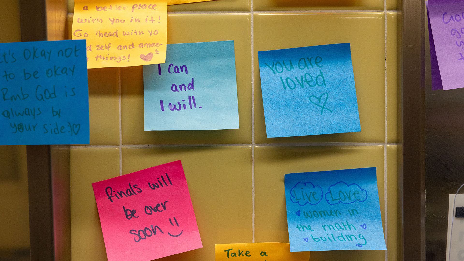 sticky notes that read, "I can and I will," "finals will be over soon," "you are loved," live love women in the math building"