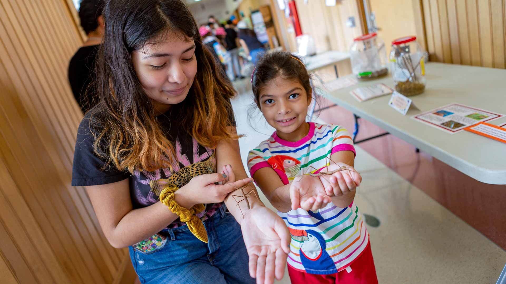 Two visitors at the insect petting zoo