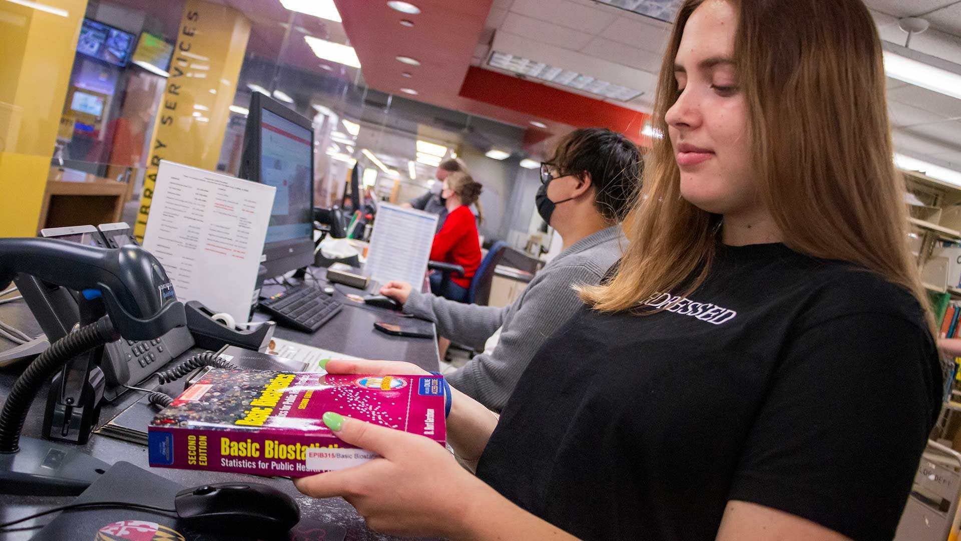 Student scans book in library